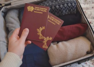 dois-passaportes-portugueses-erguido-sobre-uma-mala-de-viagem-com-roupa.-Foto-de-Cláudia-Paiva-886x590
