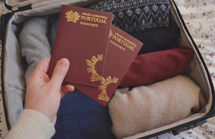 dois-passaportes-portugueses-erguido-sobre-uma-mala-de-viagem-com-roupa.-Foto-de-Cláudia-Paiva-886x590